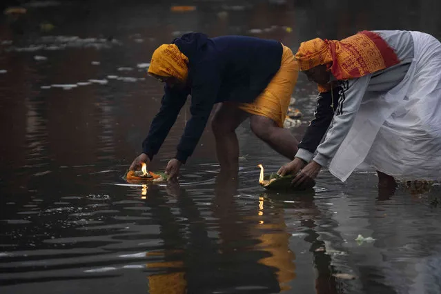 Devotees perform rituals during Poushe Aunshi festival near Kanti Bhairabh temple on the bank of Bagmati river in Kathmandu, Nepal, Thursday, January 11, 2024. During this festival devotes bath in the river and perform rituals seeking peace and blessings for their departed family members. (Photo by Niranjan Shrestha/AP Photo)