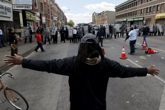 Members of the community stand between demonstrators and police officers after items were thrown and pepper spray used outside a recently looted and burned CVS store in Baltimore, Maryland, United States April 28, 2015. (Photo by Jim Bourg/Reuters)