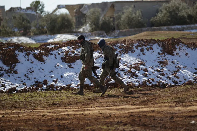 Rebels walk near snow on the outskirts of the northern Syrian town of al-Bab, Syria January 29, 2017. (Photo by Khalil Ashawi/Reuters)