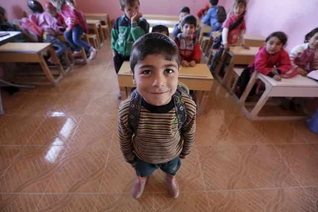 Five-year-old Omar al-Haroush poses inside a classroom in the rebel-controlled area of Maarshureen village in Idlib province, Syria  March 12, 2016. (Photo by Khalil Ashawi/Reuters)