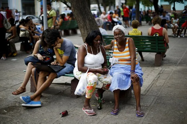 People sit near a Wi-Fi hotspot in a square at Havana, Cuba March 19, 2016. (Photo by Ivan Alvarado/Reuters)