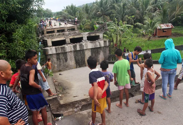 People look at the collapsed Anao-aon bridge after an earthquake hit Surigao city, southern Philippines February 11, 2017. (Photo by Roel Catoto/Reuters)