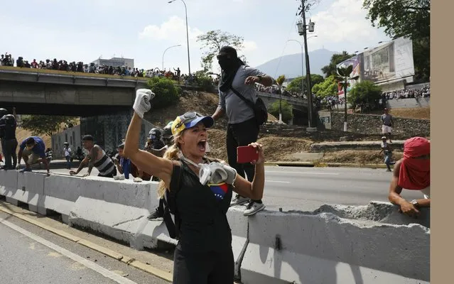 A protester chants anti-government slogans outside La Carlota airbase during clashes between the two sides in Caracas, Venezuela, Wednesday, May 1, 2019. Opposition leader Juan Guaido called for Venezuelans to fill streets around the country Wednesday to demand President Nicolas Maduro's ouster. Maduro is also calling for his supporters to rally. (Photo by Rodrigo Abd/AP Photo)