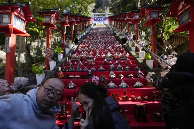 Visitors take a selfie with “hina” dolls displayed on the steps of the Tomisaki shrine in Katsuura, southeast of Tokyo, Sunday, March 3, 2024. Doll Festival, or Girls' Day, is a religious holiday of Shinto in Japan, annually celebrated on March 3 in hopes of girls' healthy growth, as the counterpart to the historically called Boys' Day, now called Children's Day, celebrated on May 5. (Photo by Hiro Komae/AP Photo)