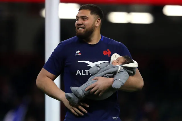 France's lock Emmanuel Meafou celebrates with his baby on the pitch after the Six Nations international rugby union match between Wales and France at the Principality Stadium in Cardiff, south Wales, on March 10, 2024. France won the game 45-24. (Photo by Geoff Caddick/AFP Photo)