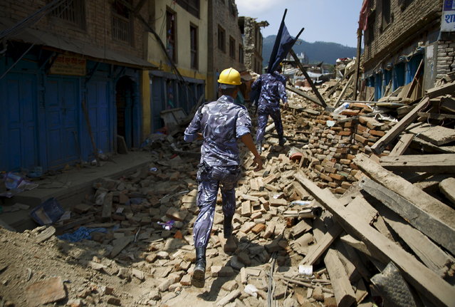 Nepalese police personnel run to rescue earthquake victims believed to be trapped after the earthquake in Sankhu May 12, 2015. (Photo by Navesh Chitrakar/Reuters)