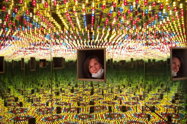 A woman looks at the art work, “The Infinity Room”, by Yayoi Kusama, part of a retrospective exhibition in the Tel Aviv Museum of Art, Israel, Monday, November 15, 2021. (Photo by Oded Balilty/AP Photo)