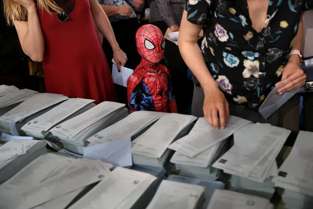 A kid in a Spiderman costume stands next to a ballot table for the European Parliament election at a polling station in Madrid, Spain, May 26, 2019. (Photo by Susana Vera/Reuters)