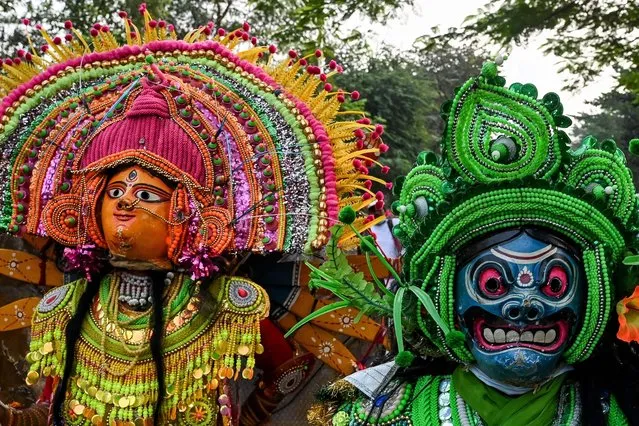 Traditional folk artists perform Chhau folk dance along road as a part of celebrations after United Nations Educational, Scientific and Cultural Organisation (UNESCO) announced the inclusion of city's Hindu festival of Durga Puja in the representative List of Intangible Cultural Heritage of Humanity, in Kolkata on December 22, 2021. (Photo by Dibyangshu Sarkar/AFP Photo)