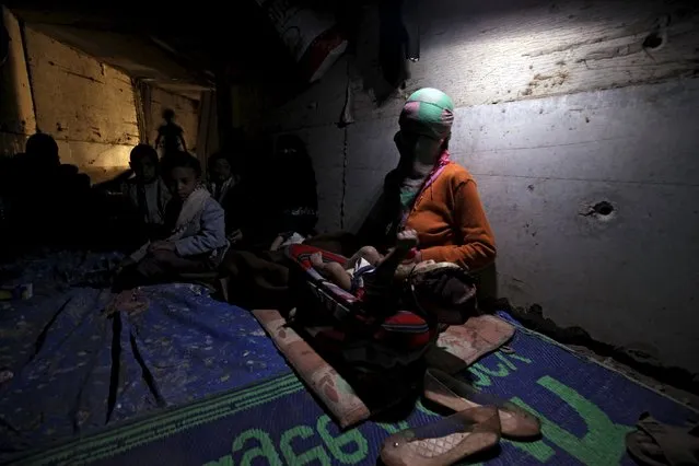 A woman holds her daughter inside an underground water tunnel with other displaced Yemeni families, after they were forced to flee their home due to ongoing air-strikes carried out by the Saudi-led coalition in Sanaa May 2, 2015. (Photo by Mohamed al-Sayaghi/Reuters)