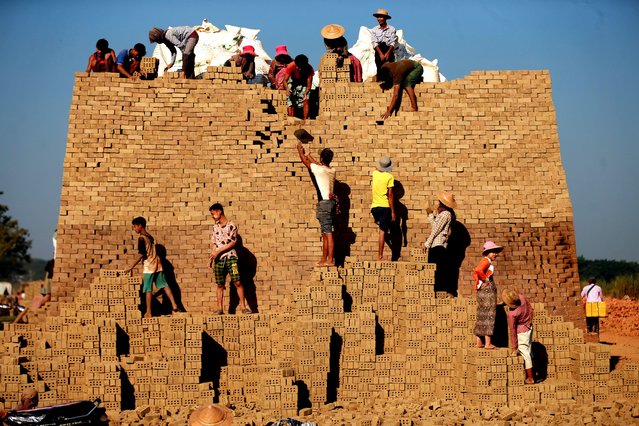 People work at a brick kiln on the outskirts of Yangon, Myanmar, December 15, 2021. (Photo by Xinhua News Agency/Rex Features/Shutterstock)