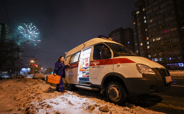 A paramedic enters an ambulance vehicle as she responds to a call received by Ambulance Station No 3 of Rostov-on-Don's Emergency Care Hospital on New Year's Day in Rostov-On-Don, Russia on January 1, 2022. (Photo by Erik Romanenko/TASS)
