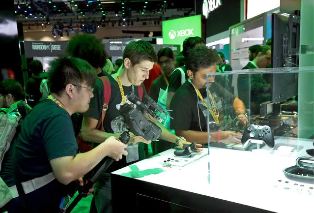 E3 2015 attendees interact with the Xbox Elite Wireless Controller at the Xbox booth at E3 in Los Angeles on Tuesday, June 16, 2015. (Photo by Casey Rodgers/Invision for Microsoft/AP Images)