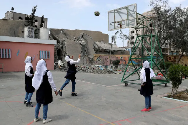 Palestinian students play basketball inside their damaged school nearby a building that was destroyed by Israeli air strikes, in Gaza City on May 7, 2019. (Photo by Mohammed Salem/Reuters)