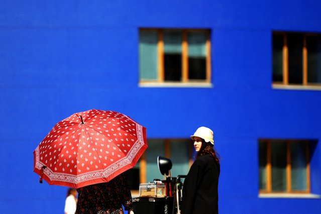 A woman protects herself from the sun during hot weather in Bilbao, Spain, April 13, 2024. (Photo by Vincent West/Reuters)