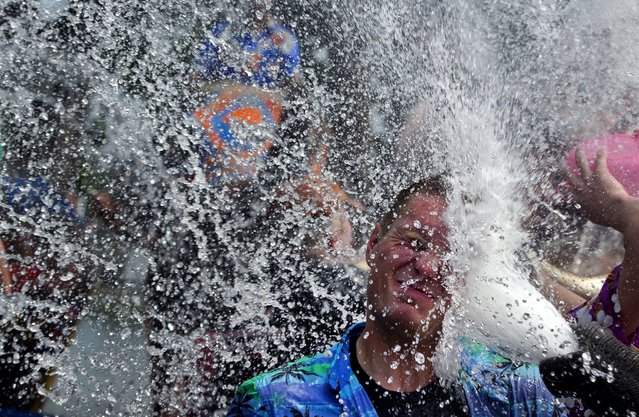 A foreign tourist is splashed with water by an elephant during a water battle in the street as people celebrate ahead of the Songkran Festival in Ayutthaya province, Thailand, April 9, 2014. Songkran, the Thai New Year which starts on April 13 this year, is celebrated in various ways, including splashing water at each other. (Photo by Pornchai Kittiwongsakul/AFP Photo)