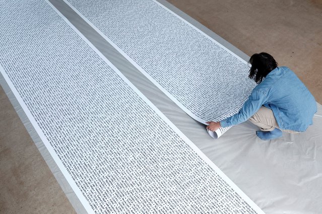 French artist Baptiste Chebassier unrolls his artwork, made from rolls of recycled paper on which names of 30,249 Olympic medallists will be written, at the Chebassier workshop in Saint-Ouen, near Paris, France, on April 5, 2024. (Photo by Noemie Olive/Reuters)