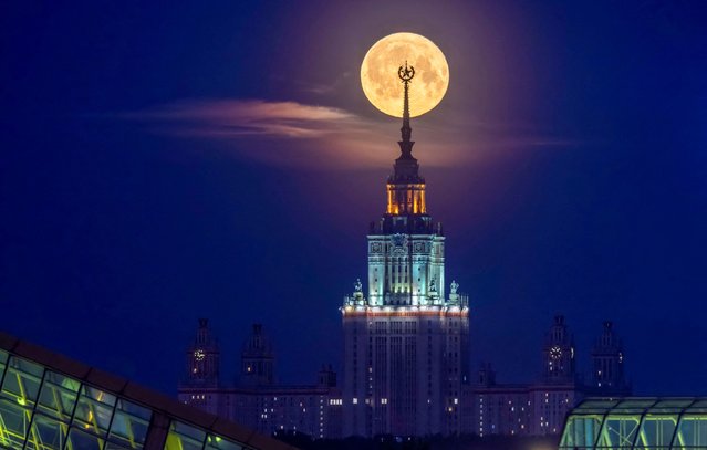 The full moon, also known as the Flower Moon, is seen behind Lomonosov Moscow State University in the city of Moscow, Russia, on May 24, 2024. (Photo by Marina Lystseva/Reuters)