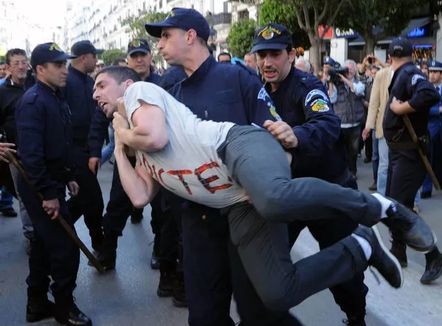 Algerian police arrest a protestor from the Barakat movement (meaning in Algerian Arabic “That's enough”), as they demonstrate in Algiers on April 16, 2014 against Algeria's current President Bouteflika Abdelaziz running for a fourth term in the presidential elections. More than 260,000 police have deployed across the country to guarantee security in the 50,000 polling booths set up to accommodate the 23 million Algerians eligible to vote in the presidential race, which is being contest by six candidates. (Photo by Farouk Batiche/AFP Photo)