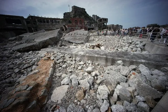 In this June 29, 2015 photo, forlorn buildings are seen at Hashima Island, commonly known as Gunkanjima, which means “Battleship Island”, off Nagasaki, Nagasaki Prefecture, southern Japan. (Photo by Eugene Hoshiko/AP Photo)