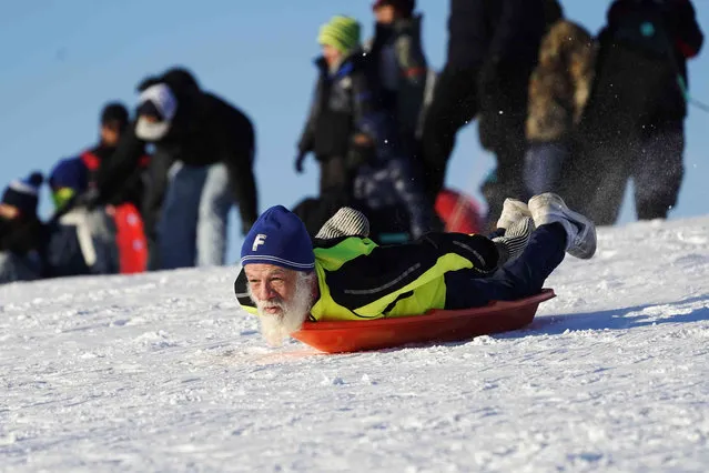 A man sleds down Cricket Hill in Chicago, Saturday, February 5, 2022. (Photo by Nam Y. Huh/AP Photo)