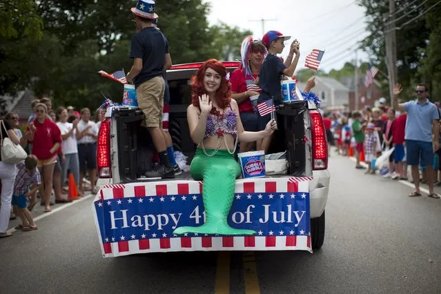 A girl dressed as a mermaid rides on the back of a pickup truck through Barnstable Village on Cape Cod, during the annual Fourth of July Parade celebrating the country's Independence Day, in Barnstable, Massachusetts, July 4, 2015. (Photo by Mike Segar/Reuters)