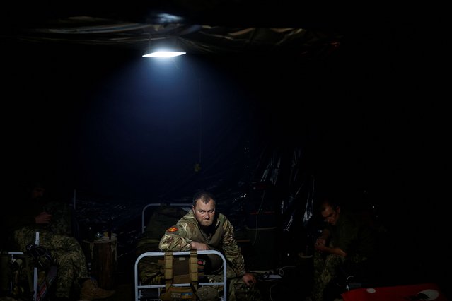Ukrainian servicemen of the 42nd Separate Mechanized Brigade wait for a combat work inside a dugout at a position in Kharkiv region, Ukraine on May 16, 2024. (Photo by Valentyn Ogirenko/Reuters)