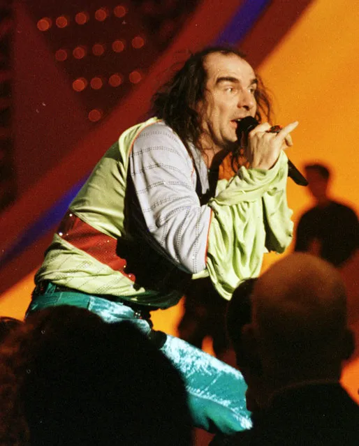 In this Saturday, May 9, 1998 file photo, Germany's Guildo Horn performs on stage in the final dress rehearsal ahead of the final. Horn, a cult figure in Germany, made waves in 1998 with his velvet trousers, platform shoes and ruffled shirt. He rushed across the stage, playing cowbells and climbing up on the scaffolding, too. Similar eccentricities are expected at this year's event in the Swedish capital of Stockholm, the final of which takes place on Saturday, May 14. (Photo by Louisa Buller/AP Photo)