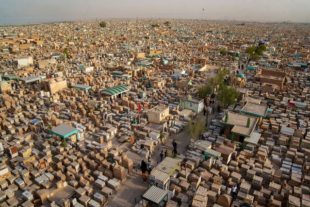 An aerial view shows people visiting the graves of loved ones at the Wadi al-Salam cemetery in Iraq's shrine city of Najaf on June 17, 2024 on the second day of the Muslim holiday of Eid al-Adha or the Feast of Sacrifice. (Photo by Qassem Al-Kaabi/AFP Photo)