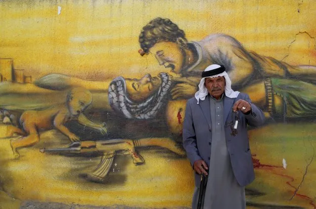 Palestinian refugee Shaher al Khatib, 76, holds keys symbolising the loss of his home as he poses for a photograph in front of a mural ahead of the 68th anniversary of Nakba at Qalandia refugee camp near the West Bank city of Ramallah May 14, 2016. (Photo by Ammar Awad /Reuters)