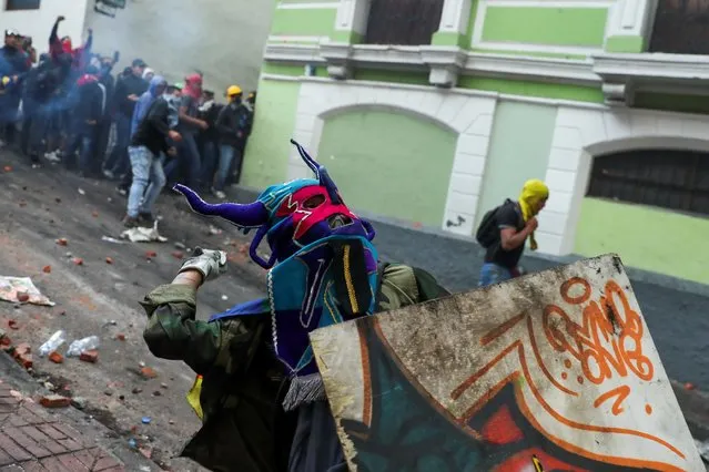 A demonstrator throws a stone during a protest against Ecuador's President Lenin Moreno's austerity measures in Quito, Ecuador, October 9, 2019. The protests first erupted in the Andean nation of 17 million people a week ago when Moreno cut fuel subsidies as part of a package of measures in line with a $4.2 billion IMF loan. (Photo by Ivan Alvarado/Reuters)