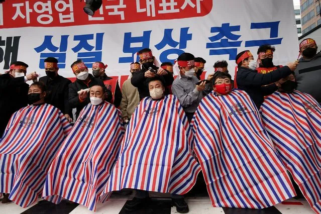 South Korean business owners have their heads shaved during a protest against the government's new social distancing rules which came into effect earlier this month near the National Assembly in Seoul, South Korea, January 25, 2022. (Photo by Kim Hong-Ji/Reuters)