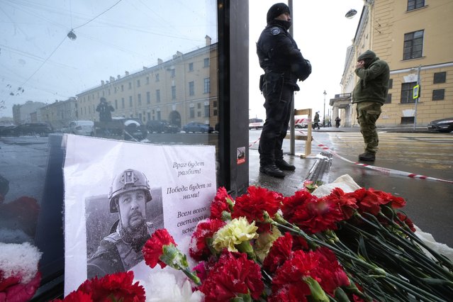 Flowers and a poster with a photo of blogger Vladlen Tatarsky placed near the site of an explosion at the “Street Bar” cafe in St. Petersburg, Russia, Monday, April 3, 2023. An explosion tore through a cafe in Russia’s second-largest city, killing a well-known military blogger and strident supporter of the war in Ukraine. Some reports said a bomb was embedded in a bust of the blogger that was given to him as a gift. Russian officials said Vladlen Tatarsky was killed Sunday as he led a discussion at the cafe in the historic heart of St. Petersburg. (Photo by Dmitri Lovetsky/AP Photo)