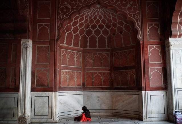 A Muslim woman reads Koran before breaking fast on the second day of holy month of Ramadan at the Jama Masjid (Grand Mosque) in the old quarters of Delhi, India, April 4, 2022. (Photo by Adnan Abidi/Reuters)