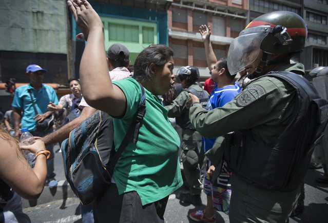 A woman confronts a National Guard soldier during a protest demanding food, a few blocks from Miraflores presidential palace in Caracas, Venezuela, Thursday, June 2, 2016. (Photo by Fernando Llano/AP Photo)
