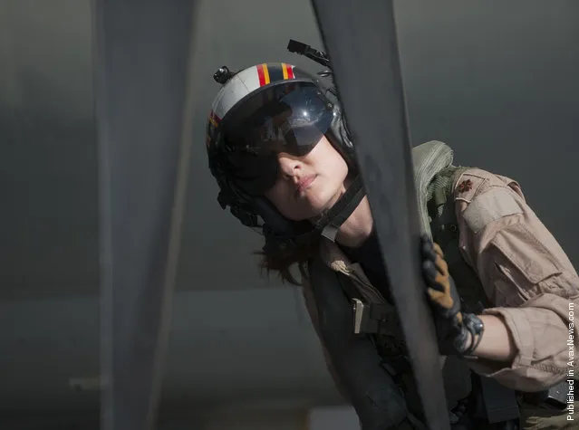 Plane Commander Lt. Cmdr. Tara Refo, assigned to Carrier Airborne Early Warning Squadron (VAW) 125, inspects the aircraft's propellers before joining four other VAW-125 officers in flying the first all-female-crewed combat mission in an E-2C Hawkeye aboard the Nimitz-class aircraft carrier USS Carl Vinson (CVN 70)