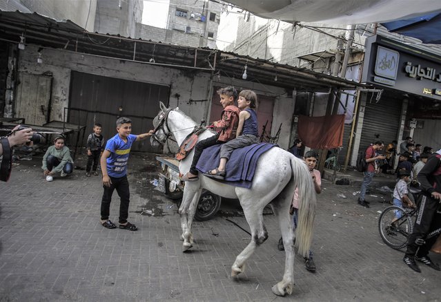 Two children ride a horse at Jabalia refugee camp as they celebrate on the second day of the feast of Eid al-Fitr, which marks the end of the Muslim holy month of Ramadan on May 3, 2022. (Photo by Mahmoud Issa/Quds Net News via ZUMA Press/Rex Features/Shutterstock)
