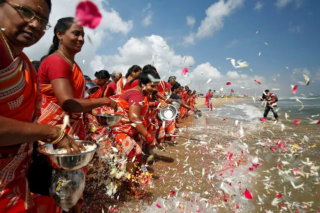 Women scatter flower petals in the waters of the Bay of Bengal during a prayer ceremony for the victims of the 2004 tsunami on the 15th anniversary of the disaster, at Marina beach in Chennai, India, December 26, 2019. (Photo by P. Ravikumar/Reuters)