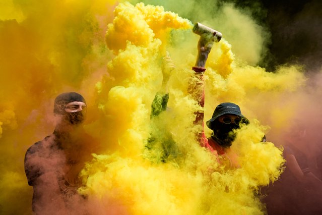 Protestors light flares during a demonstration organised in memory of Clement Meric, in Paris, on June 4, 2023. Ten years after the death of anti-fascist activist Clement Meric in 2013 following a brawl with skinheads, several gatherings are being organised in his memory, culminating in a demonstration in Paris on June 4, 2023. (Photo by Alain Jocard/AFP Photo)