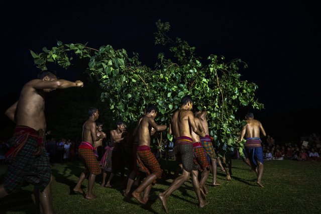 Indian Rabha tribal Hindu priests walk around tree branches as they perform rituals during Baikho festival at Gamerimura village along the Assam Meghalaya border, west of Gauhati, India, Saturday, June 4, 2022. (Photo by Anupam Nath/AP Photo)