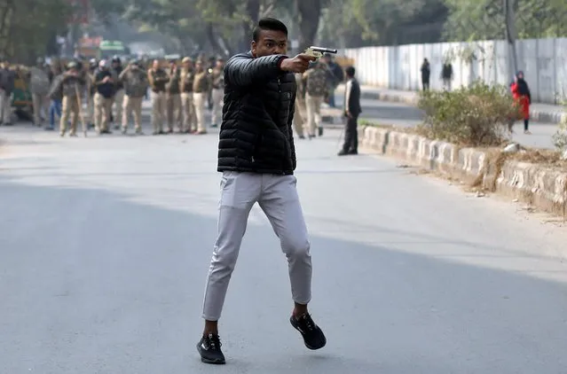An unidentified man brandishes a gun during a protest against a new citizenship law outside the Jamia Millia Islamia University in New Delhi, India, January 30, 2020. The gunman went live on Facebook to warn he was taking his “final journey” before firing at the protest. (Photo by Danish Siddiqui/Reuters)