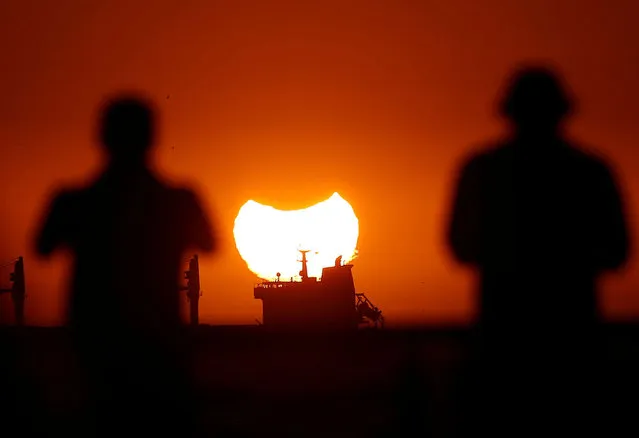 A partial solar eclipse is pictured during sunset in Vina del Mar, Chile on April 30, 2022. (Photo by Rodrigo Garrido/Reuters)