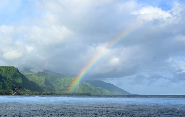 A rainbow is seen as surfers compete in the men's Shiseido Tahiti Pro surfing competition elimination round, in Teahupo'o, on the French Polynesian Island of Tahiti, on May 29, 2024. Teahupo'o will host the surfing event of the Paris 2024 Olympic Games. (Photo by Jerome Brouillet/AFP Photo)