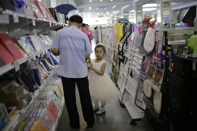 In this Monday, June 19, 2017, photo, a young girl and her father shop in the stationery department at the Potonggang department store in Pyongyang, North Korea. (Photo by Wong Maye-E/AP Photo)