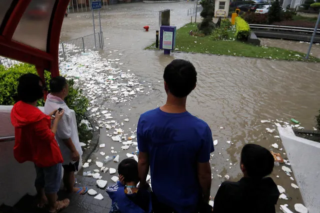 People look at a flooded street as Typhoon Hato hits Hong Kong, China on August 23, 2017. (Photo by Tyrone Siu/Reuters)