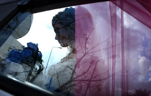 Sundus Garis, a 16-year-old displaced Iraqi woman from the Yazidi community who fled Sinjar, is pictured through a car's window during her wedding ceremony in the northernwestern Iraqi Kurdish city of Dohuk, near the border with Turkey, on January 23, 2020. Sinjar, a region west of the northern Iraqi city of Mosul that was overrun by the fanatic Islamic State (IS) group five years ago, is the historic home of the Yazidi minority which under went a brutal campaign waged by IS jihadists who forced children to become soldiers and used thousands of women as s*x slaves. Only a sliver of Sinjar's native population of 500,000 Yazidis has returned since their region was taken back by Iraqi forces from IS in 2017, with the rest saying persistent destruction, the lack of services and the tense security situation have kept them in camps. (Photo by Safin Hamed/AFP Photo)