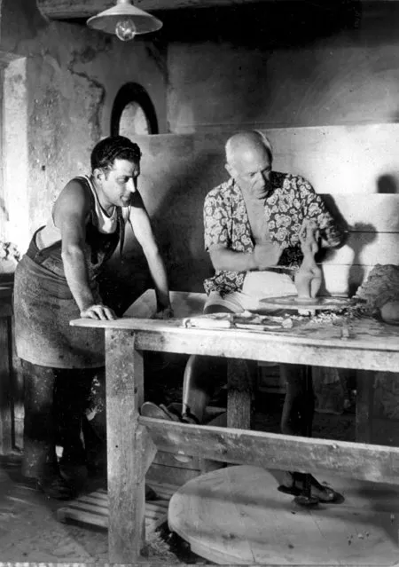 Pablo Picasso models a clay statue using a foot powered potter's wheel in a factory at Vallauris on the French Riviera on August 24, 1949.  Looking on at left is an unidentified factory worker. (Photo by AP Photo)