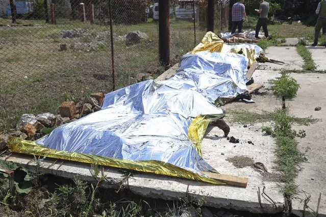 Investigators examine bodies of Ukrainian military prisoners at a prison in Olenivka, in an area controlled by Russian-backed separatist forces, eastern Ukraine, Friday, July 29, 2022. Russia and Ukraine accused each other Friday of shelling a prison in Olenivka, a separatist region of eastern Ukraine, an attack that reportedly killed dozens of Ukrainian prisoners of war who were captured after the fall of a southern port city of Mariupol in May. (Photo by AP Photo)
