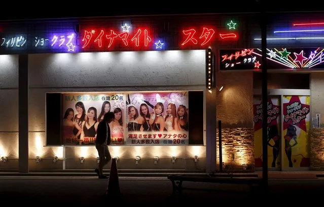 A man walks outside a club with an advertisement depicting women from the Philippines in the red light district in Ota, Gunma prefecture, north of Tokyo, Japan, April 24, 2015. (Photo by Yuya Shino/Reuters)