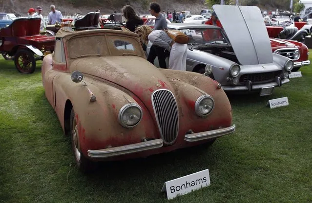 A 1953 Jaguar XK120 (L) is displayed during a preview for the Bonhams Quail Lodge car auction in Carmel, California, August 14, 2014. (Photo by Michael Fiala/Reuters)